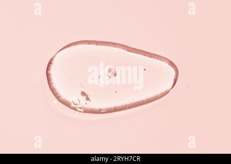 Gel liquide transparent texture à taches cosmétiques. Gel liquide transparent avec bulles isolées sur fond rose Banque D'Images