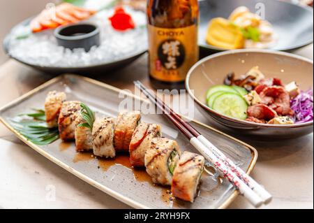 Rouleaux de sushi du canada américain avec unagi et saumon sur une table dans un restaurant. Photo de haute qualité Banque D'Images