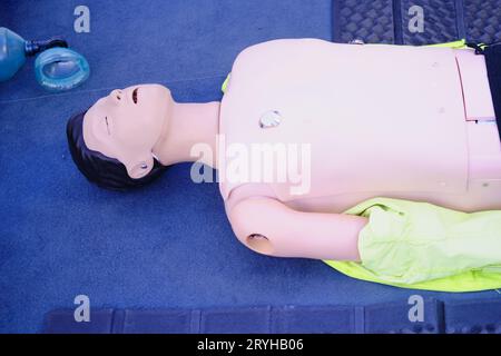 Mannequin d'entraînement ambulancier sur le sol d'une salle d'urgence d'un hôpital, entravant les compressions thoraciques dans un mannequin Banque D'Images