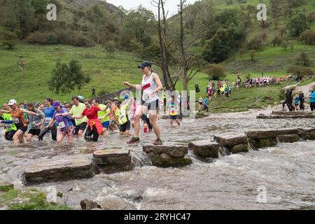 The Dovedale Dash, Thorpe, Derbyshire Peak District, Derbyshire, Angleterre, ROYAUME-UNI. 1 octobre 2023. Des concurrents courent dans le Dovedale Dash une piste de ski de fond de 4 3/4 miles partant du village de Thorpe dans le Derbyshire et dans la pittoresque vallée de Dovedale. Ici, les coureurs doivent traverser la rivière Dove soit en éclaboussant à travers la rivière ou via les tremplins bien connus. Le tableau de bord Dovedale ou le tableau de bord fonctionne depuis 1953. Crédit : Alan Keith Beastall/Alamy Live News Banque D'Images