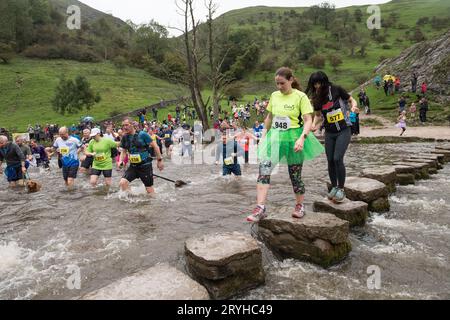 The Dovedale Dash, Thorpe, Derbyshire Peak District, Derbyshire, Angleterre, ROYAUME-UNI. 1 octobre 2023. Des concurrents courent dans le Dovedale Dash une piste de ski de fond de 4 3/4 miles partant du village de Thorpe dans le Derbyshire et dans la pittoresque vallée de Dovedale. Ici, les coureurs doivent traverser la rivière Dove soit en éclaboussant à travers la rivière ou via les tremplins bien connus. Le tableau de bord Dovedale ou le tableau de bord fonctionne depuis 1953. Crédit : Alan Keith Beastall/Alamy Live News Banque D'Images