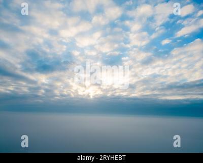 Vue aérienne. Voler dans le brouillard, voler dans la brume au-dessus des nuages tôt le matin dans le soleil levant. Prise de vue aérienne. Vol au-dessus de la cl Banque D'Images