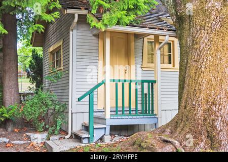 Porte et le porche de la petite maison d'habitation en vertu de l'arbre. Banque D'Images