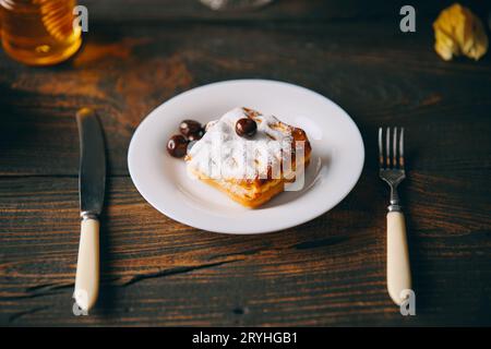 Pâtisseries maison à la cerise sur l'assiette sur le fond en bois sombre. Banque D'Images