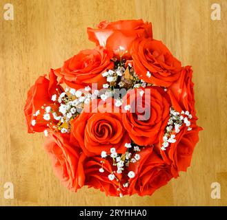 Beau bouquet de roses rouges sur une table en bois Banque D'Images