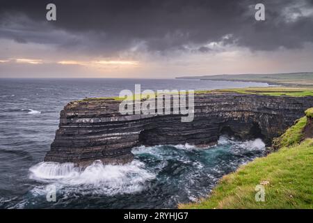 Pêcheur debout au bord des falaises de Downpatrick Head à Dawn, Irlande Banque D'Images