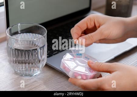 Femme tri Pills Organizer tirs hebdomadaires gros plan de boîte à pilules médicales avec des doses de comprimés pour prendre quotidiennement des médicaments avec du blanc Banque D'Images