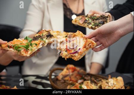 Les membres de l'équipe mangent de la pizza Banque D'Images