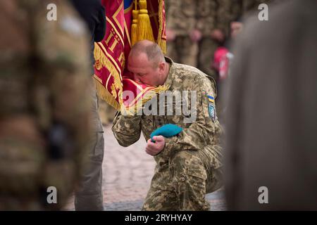 Kiev, Ukraine. 01 octobre 2023. Un soldat ukrainien embrasse un drapeau de combat présenté par le président Volodymyr Zelenskyy, lors de la célébration de la Journée des défenseurs de l'Ukraine à la forteresse de Kiev, le 1 octobre 2023 à Kiev, en Ukraine. Crédit : Présidence ukrainienne/Bureau de presse présidentiel ukrainien/Alamy Live News Banque D'Images