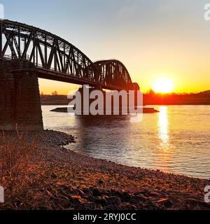 Pont ferroviaire Haus-Knipp sur le Rhin avec coucher de soleil, Duisburg, région de la Ruhr, Allemagne, Europe Banque D'Images