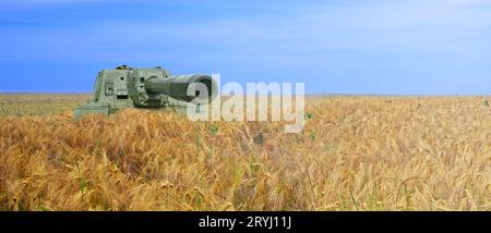 Réservoir sur le champ de blé jaune et ciel bleu. Le concept de guerre en Ukraine. Concept de couleurs du drapeau de l'Ukraine Banque D'Images