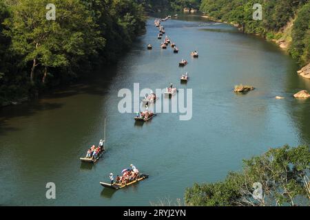 Pékin, province chinoise du Fujian. 1 octobre 2023. Les touristes apprécient la vue sur des radeaux en bambou le long du ruisseau Jiuqu dans la montagne Wuyi, dans la province du Fujian du sud-est de la Chine, le 1 octobre 2023. Les gens à travers le pays s'amusent de diverses façons le premier jour de la fête nationale. Crédit : Qiu Ruquan/Xinhua/Alamy Live News Banque D'Images