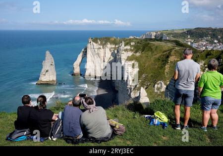 Touristes profitant de la vue de la plage d'Etretat avec ses célèbres falaises de craie et formations rocheuses côtières. France, Français, Normandie, 2023 falaises Banque D'Images