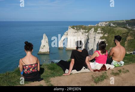 Touristes profitant de la vue de la plage d'Etretat avec ses célèbres falaises de craie et formations rocheuses côtières. France, Français, Normandie, 2023 falaises Banque D'Images