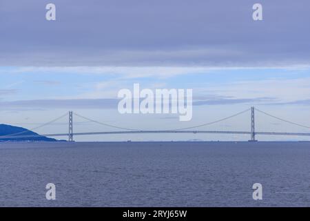 Couche nuageuse basse au-dessus du pont suspendu Akashi et eau bleue calme Banque D'Images