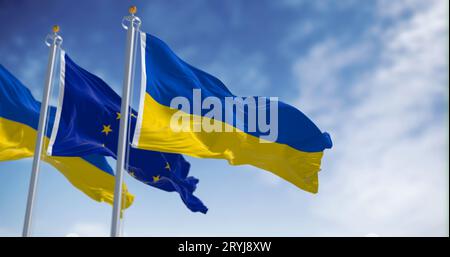 Drapeaux de l'Ukraine brandissant avec le drapeau de l'Union européenne par temps clair Banque D'Images