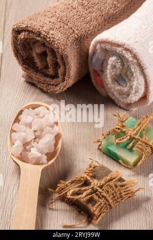 Wooden spoon with white sea salt and handmade soap for bathroom procedures with towels Banque D'Images