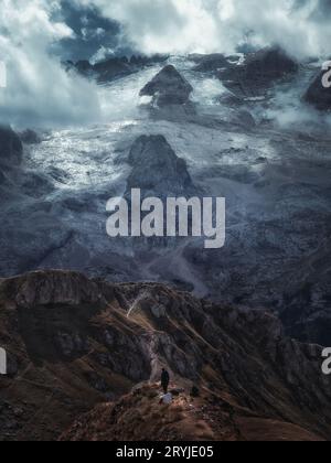 Vue spectaculaire sur la montagne de Marmolada, la plus haute montagne des Dolomites, avec des pentes couvertes de glacier et un randonneur solitaire, Italie. Banque D'Images