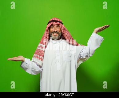 L'homme mûr arabe représente des balances avec ses mains à différents niveaux, symbolisant le concept de prise de décision, de pondération des options, Banque D'Images