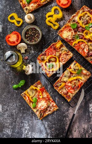 Pizza maison de style Detroit. Grande pizza Pepperoni rectangulaire avec champignons, salami et fromage sur une table en pierre. À Banque D'Images