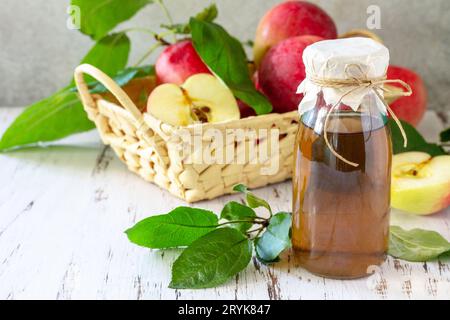 Aliments biologiques sains. Vinaigre de pomme, une bouteille de vinaigre de cidre de pomme sur une table rustique. Banque D'Images