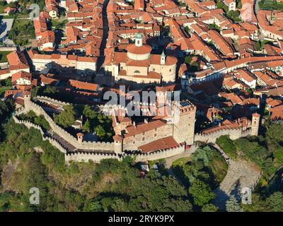 VUE AÉRIENNE. Château de Pavone surplombant la ville médiévale de Pavone Cavanese. Ville métropolitaine de Turin, Piémont, Italie. Banque D'Images