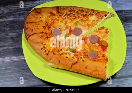 Fromage Fougasse recouvert de tranches de poivrons verts, de fromage et de saucisses coupées cuites au four, le pain de fougasse est un type de pain typiquement associé Banque D'Images