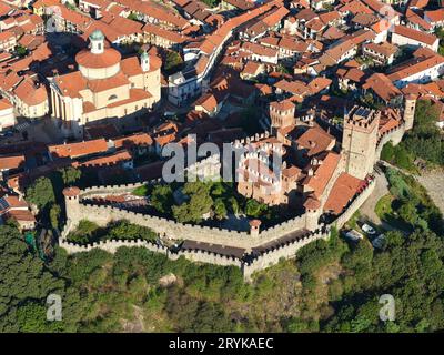 VUE AÉRIENNE. Château Pavone surplombant l'église Sant'Andrea dans la vieille ville de Pavone Canavese. Piémont, Italie. Banque D'Images