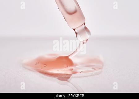 Pipette avec un gros plan cosmétique rose visqueux. Banque D'Images