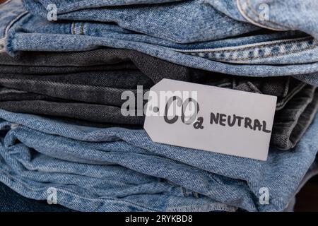 Note de texte sur les émissions neutres de CO2 sur la pile de jeans. Écologie nature friendly, changement climatique, carburant vert et concept de protection de la terre. Banque D'Images