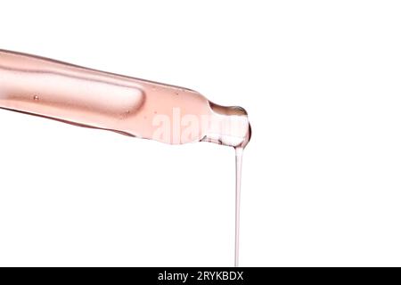 Pipette avec un gros plan cosmétique rose visqueux. Banque D'Images