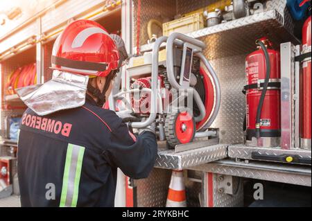 Équipement de vérification et d'entretien de pompier pour travailler dans la zone du bureau de foyer près du camion de pompiers. Banque D'Images