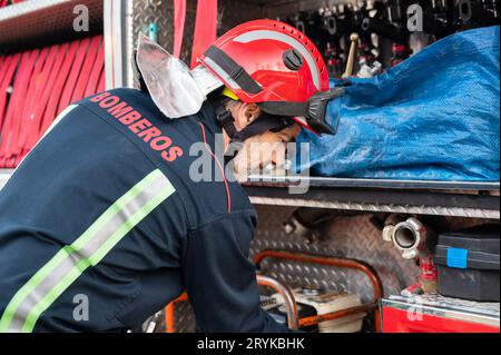 Équipement de vérification et d'entretien de pompier pour travailler dans la zone du bureau de foyer près du camion de pompiers. Banque D'Images