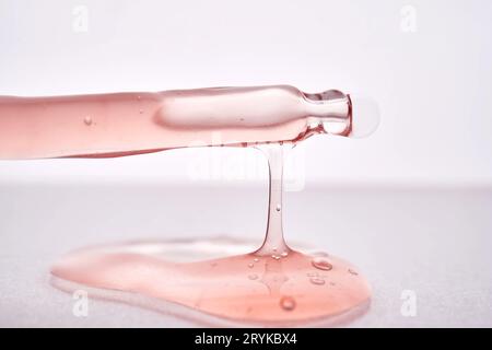 Pipette avec un gros plan cosmétique rose visqueux. Banque D'Images