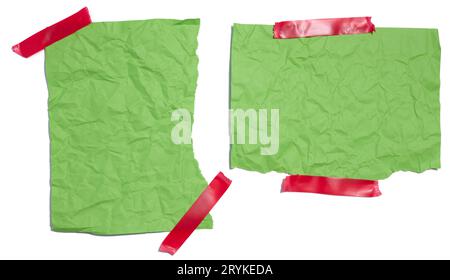 Morceaux de papier déchirés en vert avec du ruban isolant sur un fond blanc isolé Banque D'Images