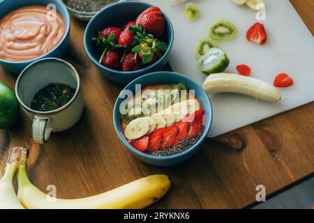 Bols avec fruits moulinés et smoothies aux baies. Dessert prêt-à-faire décoré de fruits d'été. Une alimentation saine. Banque D'Images