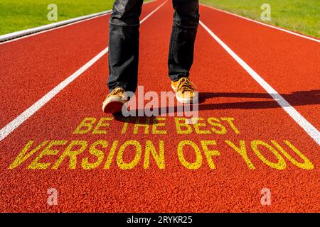 Homme marche sur la piste de course avec citation de motivation - soyez la meilleure version de vous Banque D'Images