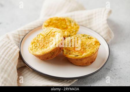 Muffins salés avec œufs, fromage feta, cheddar et épinards sur fond clair Banque D'Images