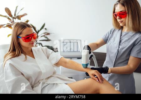 Jeune femme qui reçoit une épilation photo lors d'une visite au centre de beauté dans un salon de beauté Banque D'Images