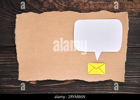 Morceau déchiré de papier artisanal avec icône d'email et bulle de discours vide, style d'art de papier. Carte de voeux, lettre, maquette d'invitation Banque D'Images
