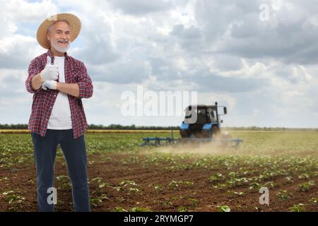 Agriculteur montrant les pouces vers le haut dans le champ. Saison de récolte Banque D'Images