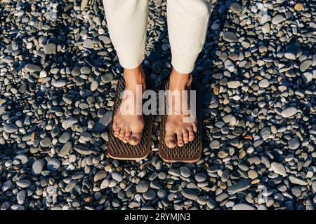 Gros plan des pieds femelles sur des planches avec des ongles pratiquer l'acupression. Banque D'Images