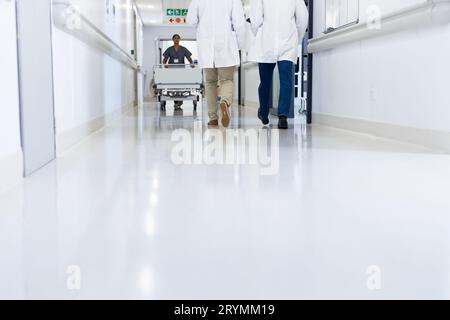 Faible nombre de médecins et de travailleurs médicaux dans un couloir hospitalier très fréquenté, espace de copie Banque D'Images