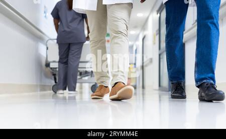 Faible nombre de médecins et de travailleurs médicaux dans un couloir hospitalier très fréquenté Banque D'Images