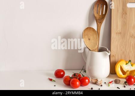 Ustensiles de cuisine en bois, légumes et épices sur fond de mur de table. Maquette de modèle de recette Banque D'Images