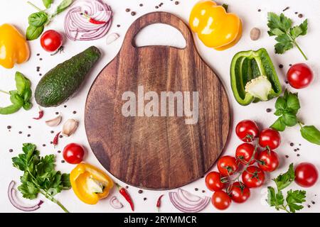 Ensemble de légumes et d'herbes autour d'une planche à découper en bois. Cuisine européenne et concept de cuisine Banque D'Images