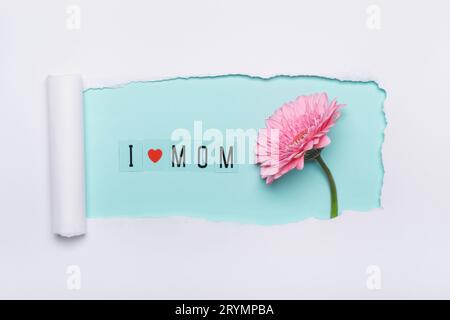 J'adore mom concept. Mise en page créative faite de texte J'aime maman et fleur rose sur fond bleu. Art de papier de trou déchiré simple Banque D'Images