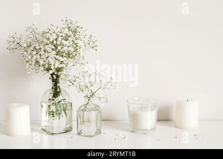 Arrangement blanc de fleurs de souffle de bébé et de bougies. Copier l'espace pour le lettrage Banque D'Images