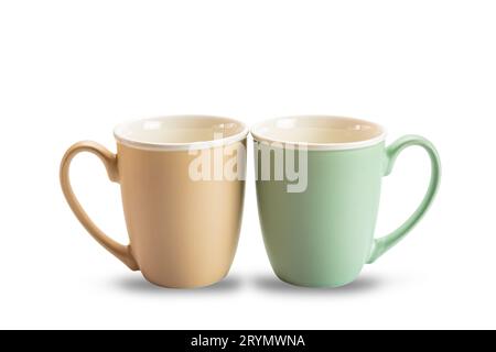 Vue latérale de deux tasses à café en céramique vides marron et vert isolé sur fond blanc. Banque D'Images