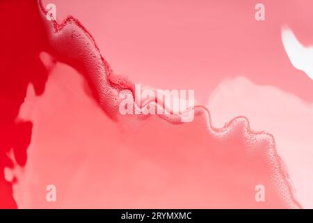 Fluide acrylique Art. Vague rouge sur fond de corail. Fond tourbillonnant abstrait ou texture Banque D'Images